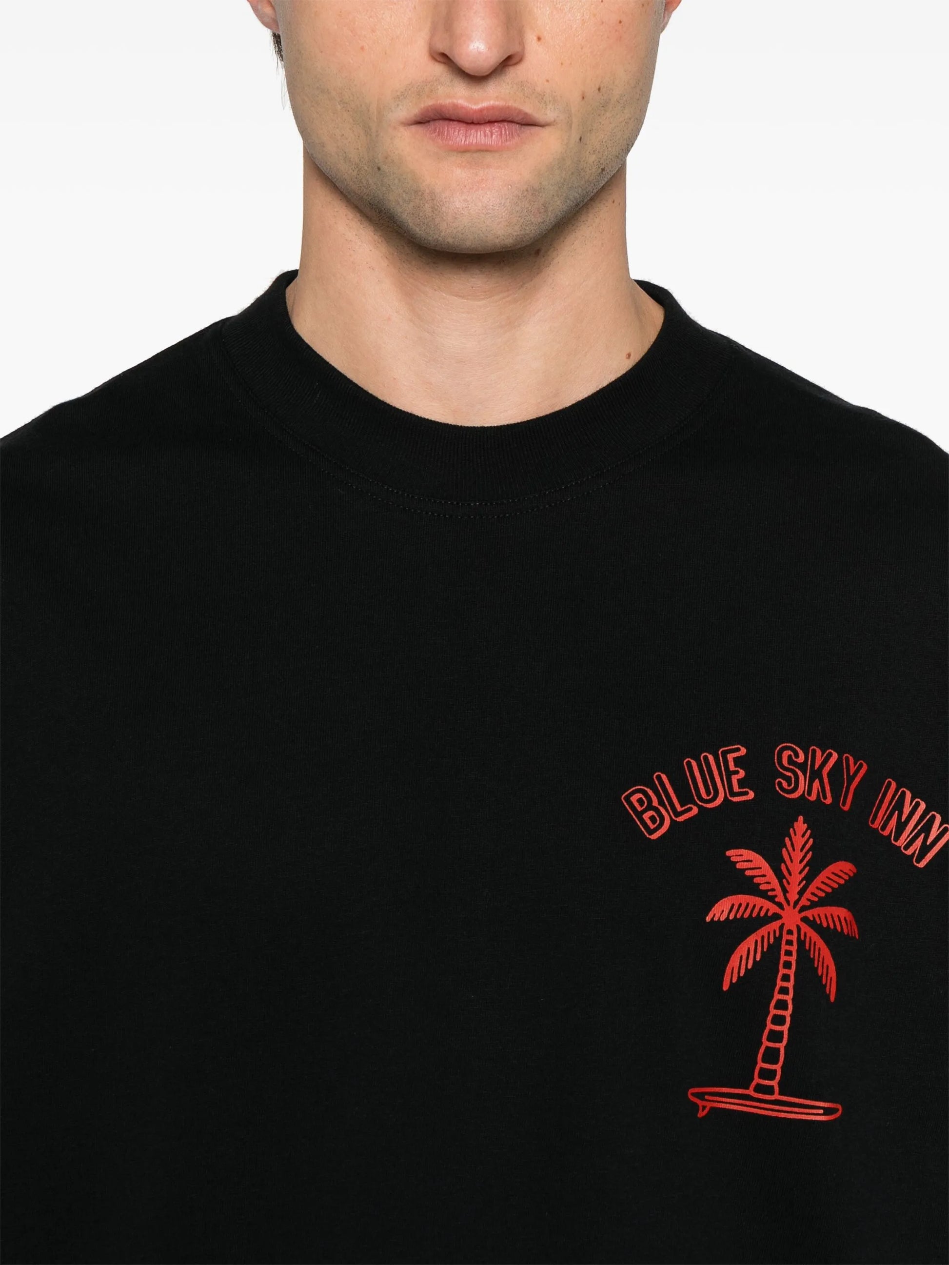 Camiseta negra con palmeras surferas
